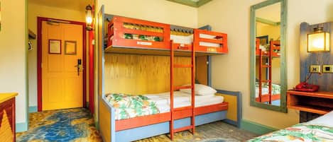 Una habitación con literas, una puerta de madera, un espejo y una alfombra estampada.