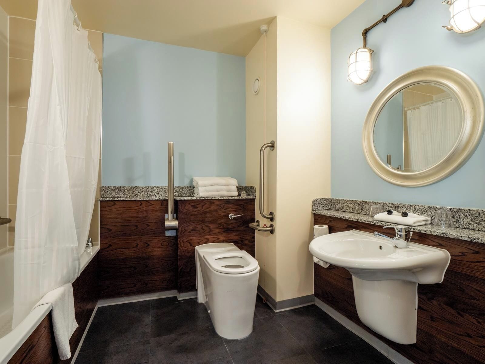 A bathroom with a bathtub, toilet, sink, and a mirror.