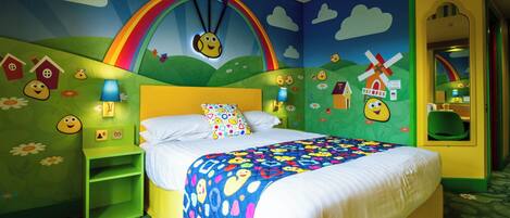 A child's bedroom with a bed, green nightstands, a colorful wall mural, and a mirror.