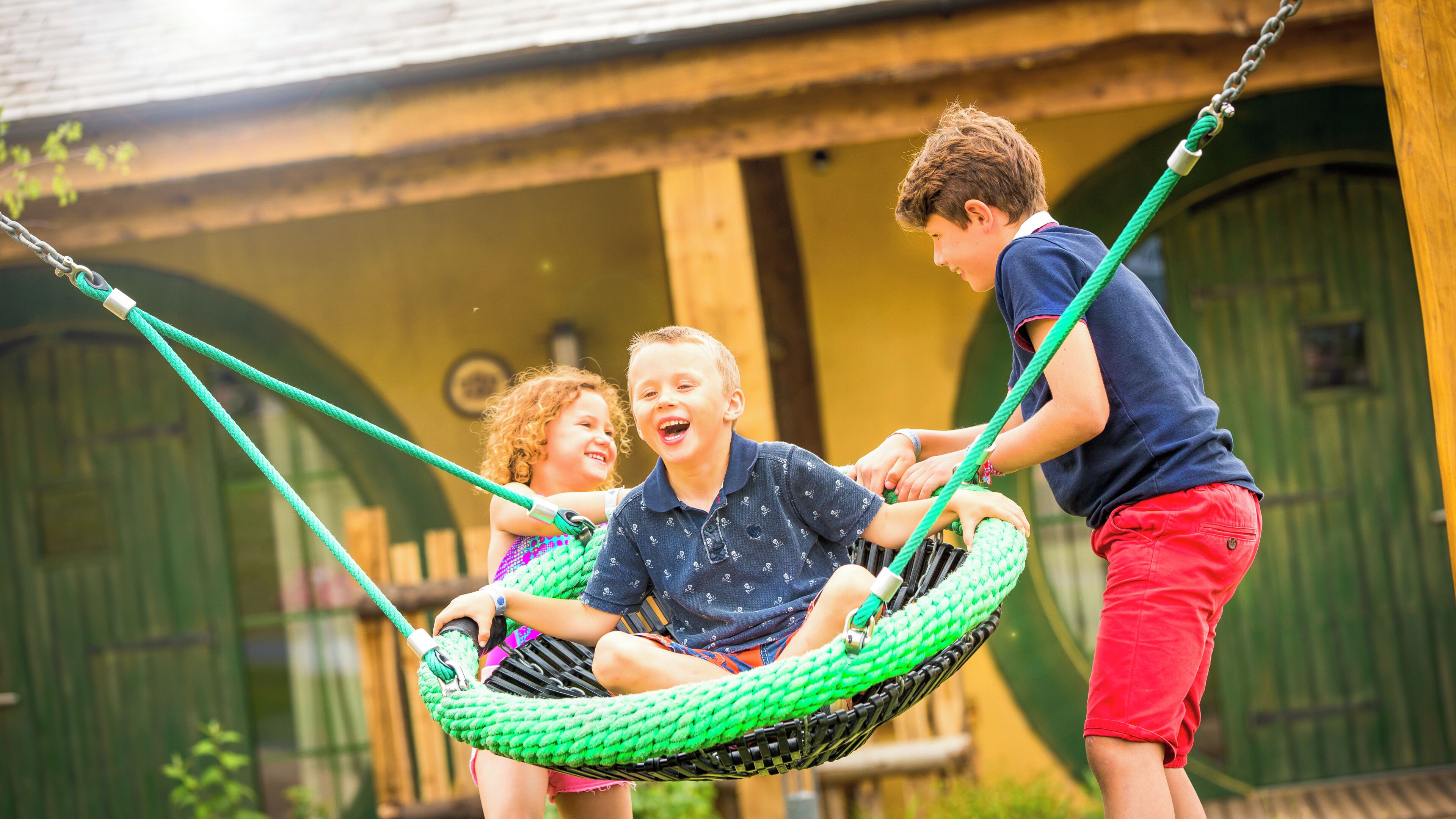 A swing set with a green rope swing.
