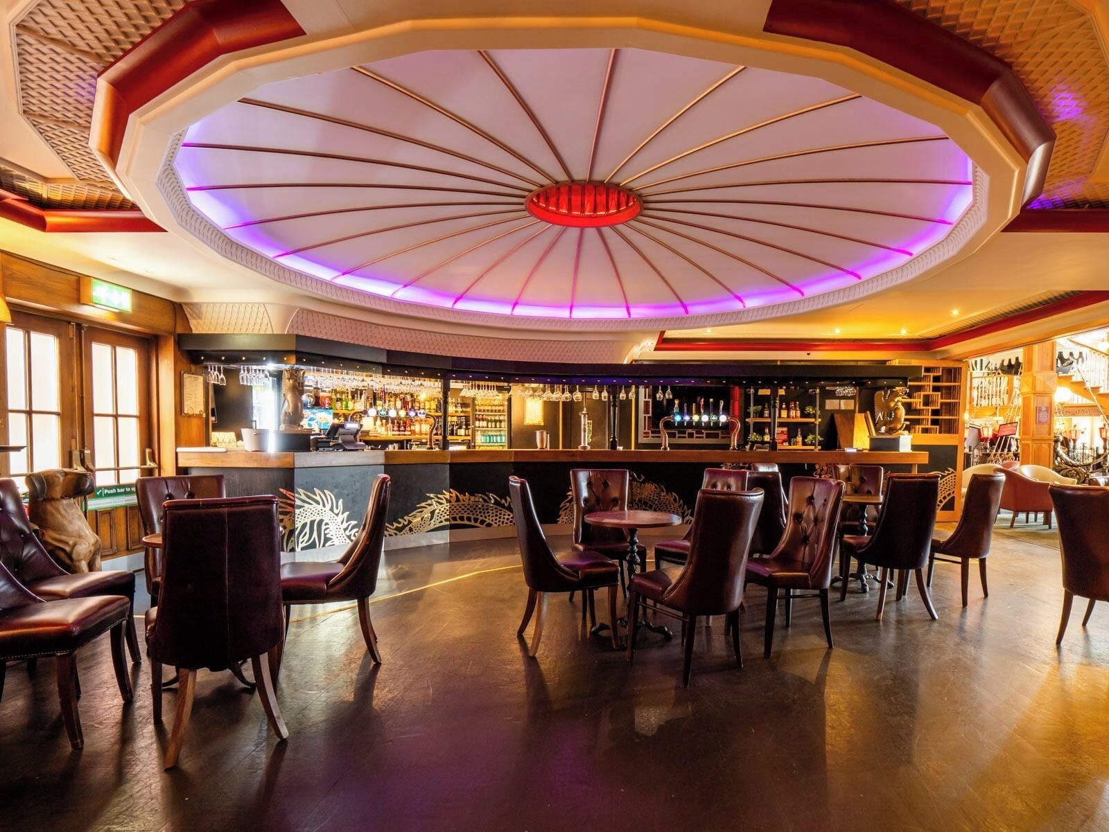 A bar area with leather chairs and a central bar counter.