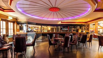 A bar area with leather chairs and a central bar counter.