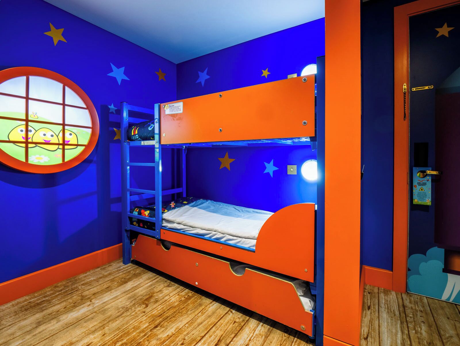 A bunk bed with a window, star decorations, and a wooden floor.