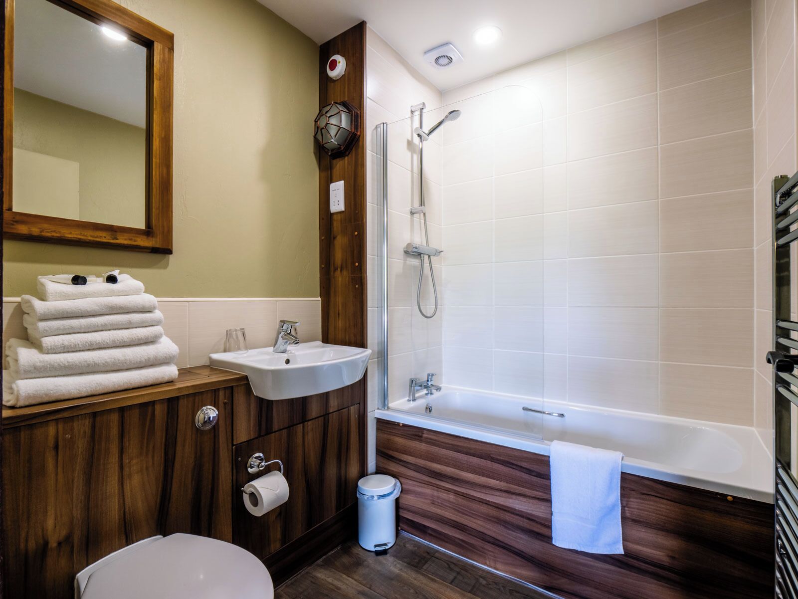 A bathroom with a wooden vanity, a sink, a toilet, a shower, and a bathtub.
