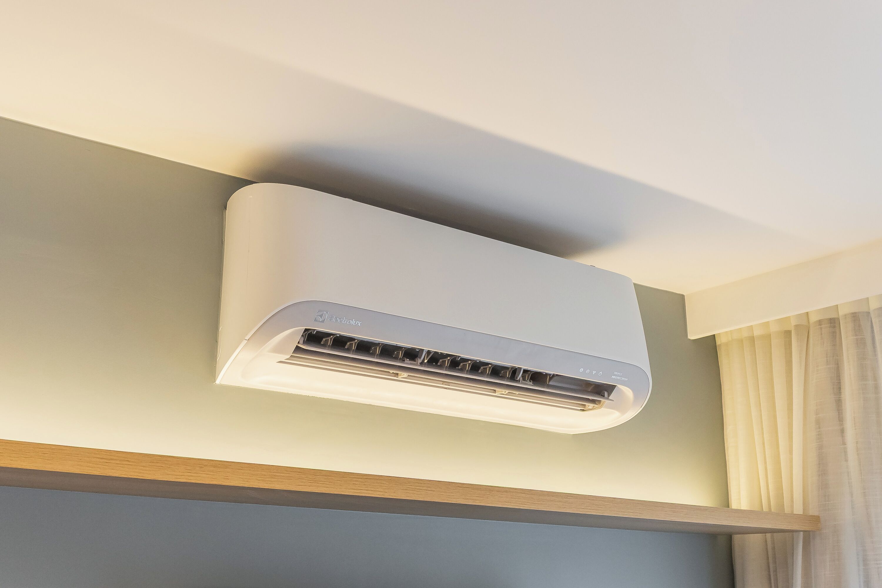 Eine moderne Klimaanlage an der Wand montiert, darüber eine Leuchte.