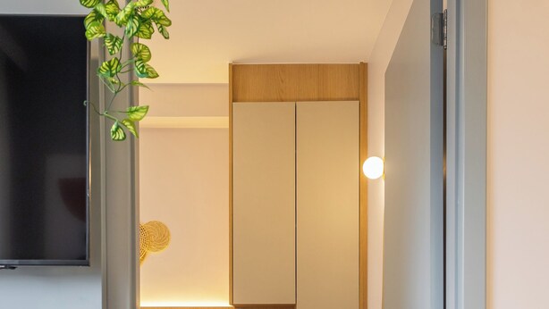 A narrow room with a bed, a bedside table, a small plant, and a wardrobe. - StayHome Chácara Klabin - AC & Gym (São Paulo)