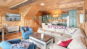 Interior acogedor de una cabaña con sala de estar, comedor y cocina.