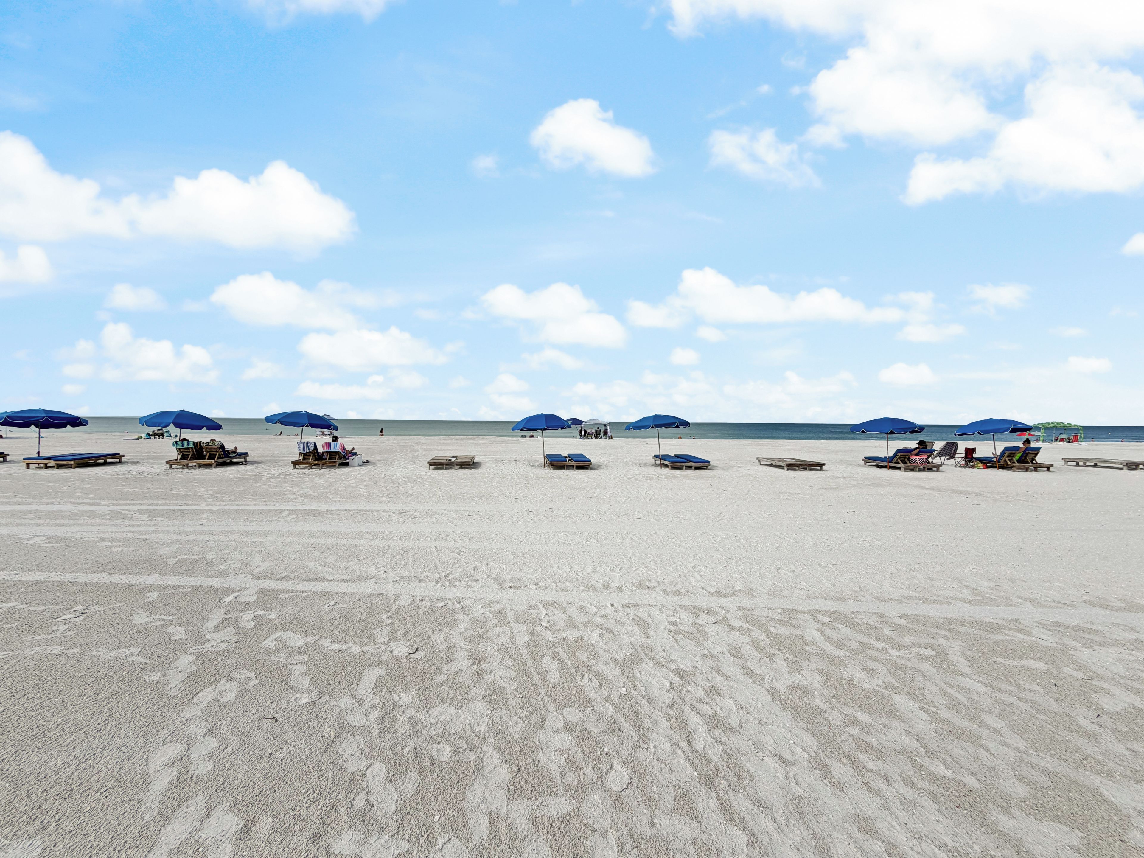 Ein Strand mit Liegestühlen und Sonnenschirmen.