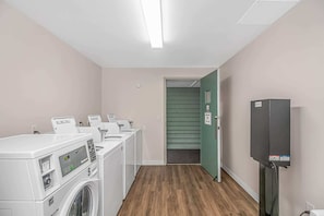 A laundry room with multiple washing machines, a dryer, and a utility room with a heater. - Myrtle Beach Resort Five Seasons Unit 4302 (Myrtle Beach)