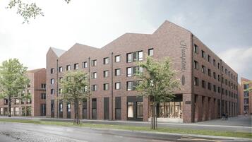 Ein modernes Gebäude mit Backsteinfassade, zahlreichen Fenstern und flachem Dach.