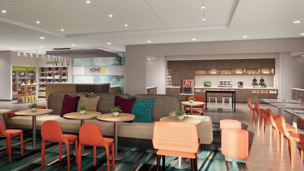 A modern hotel lobby with a reception desk, seating area, and kitchenette. - Home2 Suites By Hilton Jacksonville Mayo Clinic Area (Jacksonville)