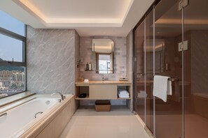 Ein modernes Badezimmer mit einer Badewanne, einer Duschkabine, einem Waschtisch mit Spiegel und Blick auf die Stadt durch ein Fenster.