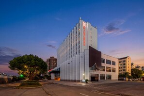 Ein modernes Hotelgebäude mit markant vertikaler Gestaltung und einem großzügigen Eingangsbereich.