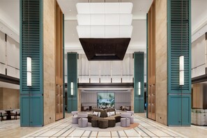 A spacious lobby with a central seating area, high ceilings, and a view of the outdoors. - Hilton Garden Inn Zhoushan Putuo District (Zhoushan)
