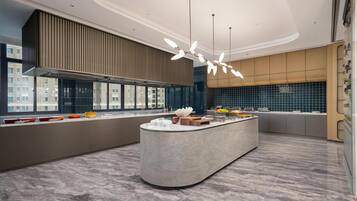 A modern kitchen with a central island, large windows, and a view of the city.