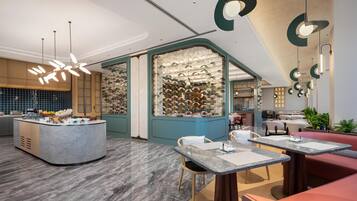 A modern restaurant interior with a central island, seating area, and decorative lighting.