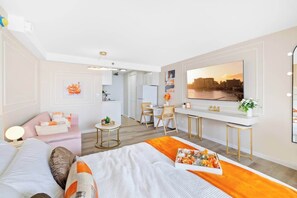 Ein modernes Hotelzimmer mit Bett, Schreibtisch, Stuhl und einem großen Fenster mit Blick auf die Stadt.