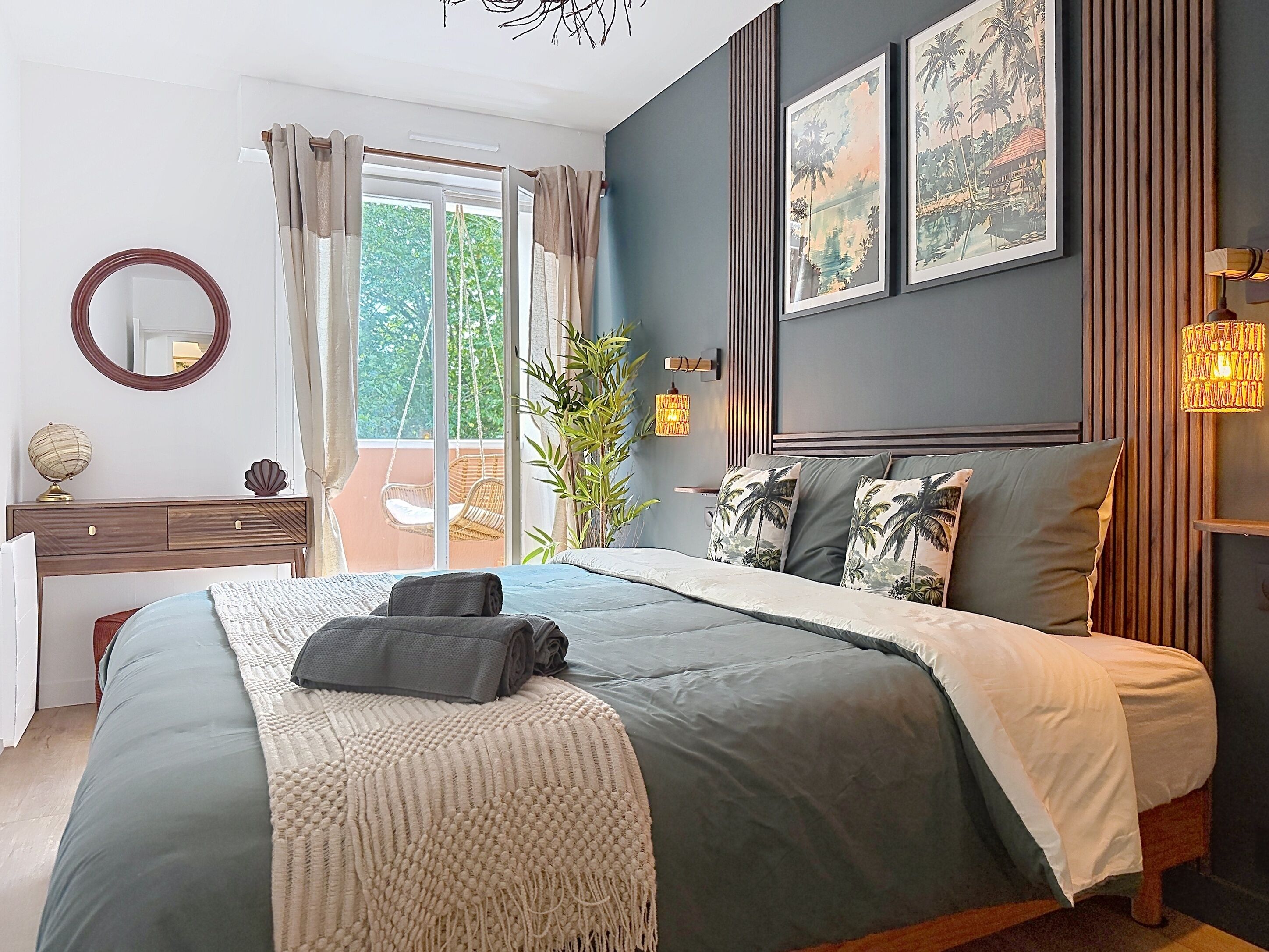 Een slaapkamer met een bed, een dressoir, een spiegel en uitzicht op de omgeving.