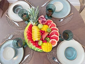 A round table with a fruit centerpiece, plates, cutlery, and glasses. - Love of the Islands • Center • Beach • Parking (Cabourg)