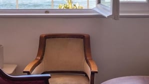 A room with a large window overlooking the ocean, a wooden chair, and a small table. - Vitaminas - Casa de Playa y Cafe (Punta del Este)