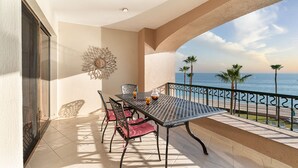 Ein Balkon mit Tisch, Stühlen und einem dekorativen Wandelement.