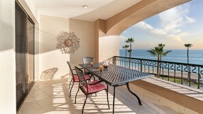 Ein Balkon mit Tisch, Stühlen und einem dekorativen Wandelement.