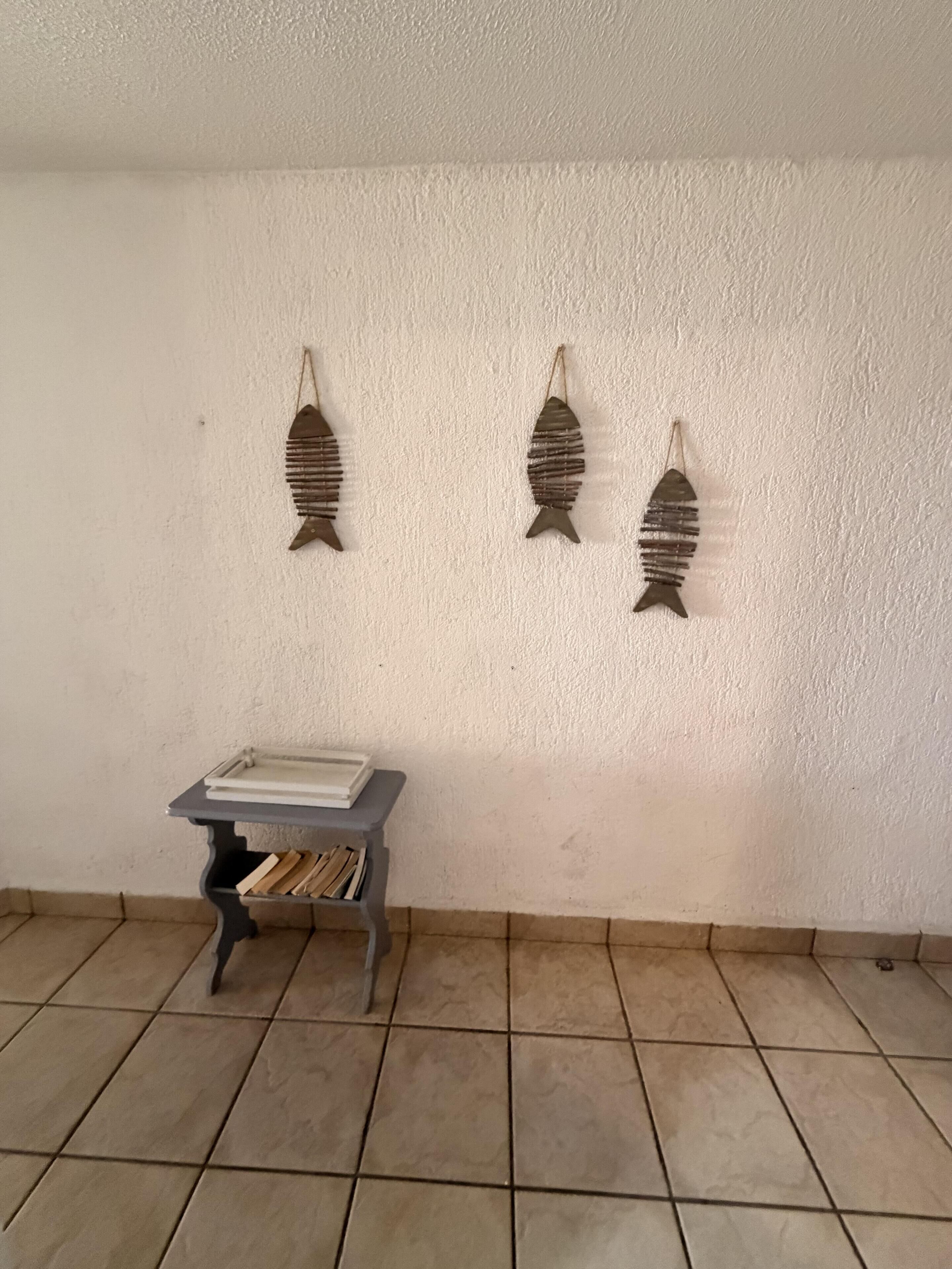 Ein Zimmer mit gefliestem Boden und einem kleinen Tisch mit Büchern.