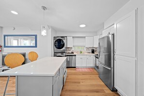 A modern kitchen with white cabinets, stainless steel appliances, and wooden flooring. - Three bedrooms | Bright living room | Free parking (Jersey City)