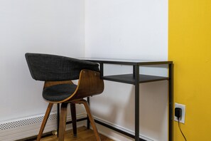 A corner desk with a chair, a power outlet, and a yellow wall. - Three bedrooms | Bright living room | Free parking (Jersey City)