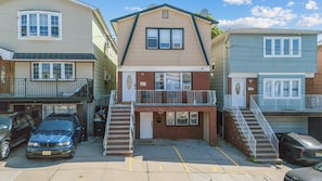A multi-story residential building with a central entrance, a small balcony, and a garage. - Three bedrooms | Bright living room | Free parking (Jersey City)