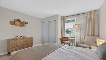 Une chambre à coucher comprenant un lit, un bureau, une chaise, une armoire et une lampe.