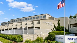 A building labeled 'Mariner's Court' with a flagpole and a sign. - South Rehoboth | Ocean Block | Parking (Rehoboth Beach)