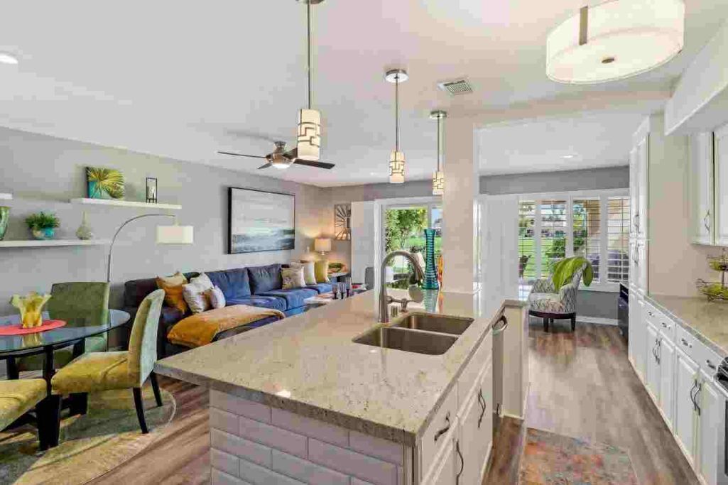 A modern kitchen with a central island, built-in cabinets, and pendant lighting.