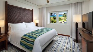 A hotel room with a large bed, a television, a window with a view of the ocean, and a wooden headboard. - Luxury Ocean View Marriott's Kauai Lagoons - 2BR/2BA villa. Sleeps 6. (Lihue)