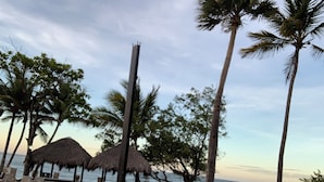 A beach with thatched umbrellas, palm trees, and lounge chairs. - Royal Villa Spacious 4-bedroom house in tranquil Puerto Plata. January 22-28th (Puerto Plata)