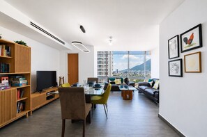 A modern living room with a dining area, large windows, and a view of a cityscape. - ¡A pasos de Santa Lucía! 5 beds 3BR2br 8 guests (Monterrey)