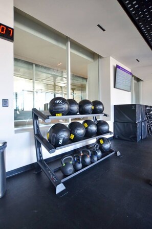 Un espace dédié à la musculation, équipé de sangles de suspension TRX et de kettlebells.