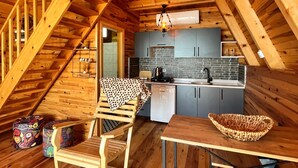 Un interior de madera con cocina, comedor y escalera.