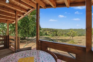 Una terraza de madera con vista a un paisaje rural.