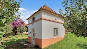 Un petit bâtiment d’un seul étage, doté d’un toit recouvert de tuiles, d’une porte et d’une fenêtre.