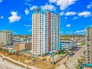 A high-rise hotel with multiple floors, a swimming pool area, and a parking lot. - Palace 1909 Ocean View Studio (Myrtle Beach)