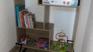 Una libreria in legno con diversi giochi da tavolo e puzzle.