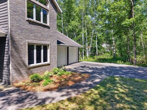 A two-story house with a garage, surrounded by trees and a well-maintained lawn. - Dog Friendly Home in Sturgeon Bay with fire pit (Sturgeon Bay)