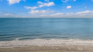Een strand met helderblauw water en een zandstrand.