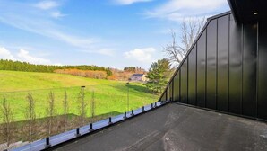 Edifici modern amb façana metàl·lica i zona pavimentada al davant.
