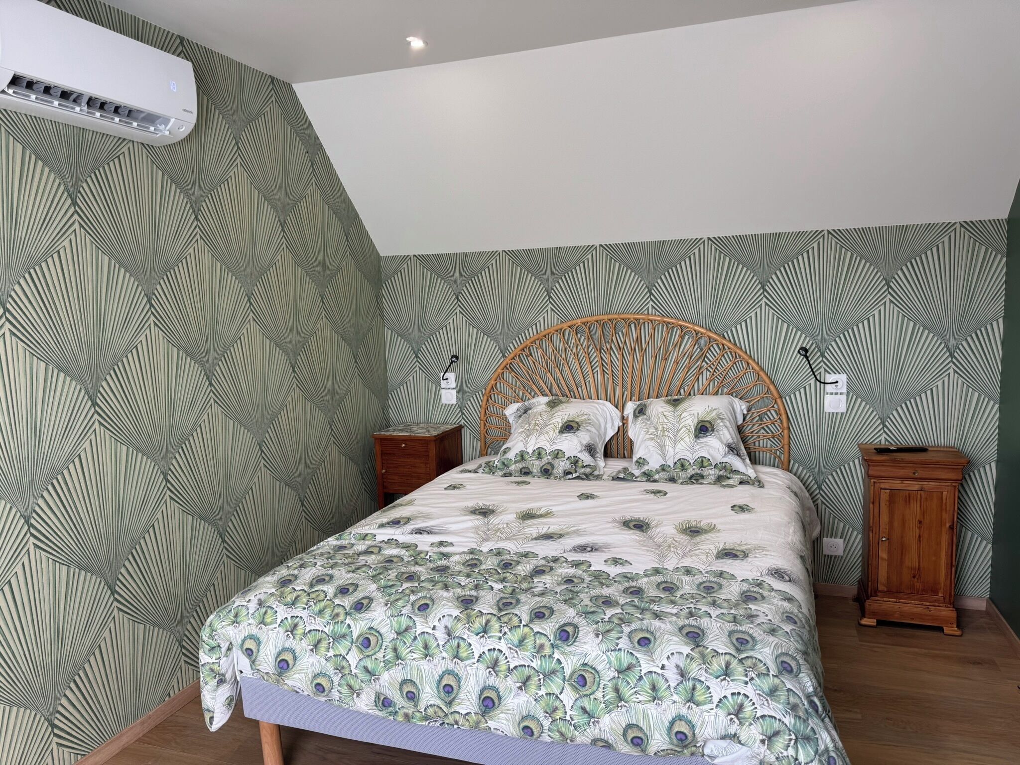 A bedroom with a bed, a nightstand, a wardrobe, and a wall-mounted air conditioner.