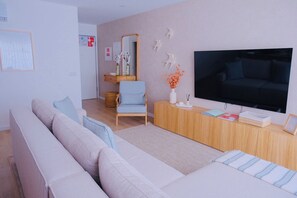 A living room with a sofa, armchair, TV, and a wooden console. - Swallows' Refuge | Monte Gordo (Monte Gordo)