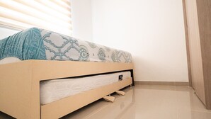 Ein Bett mit einem gemusterten Bettbezug, einer Matratze und einem Holzrahmen.