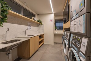Una cocina moderna con un lavamanos, encimera y una lavadora.