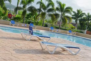 A swimming pool with lounge chairs and palm trees in the background. - Sumfest ~ Draxhall ~ 24hr Gated ~ Pool (St Ann Jamaica)